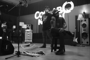 a man sitting on a stool in front of a microphone — Foto por Rendy Novantino na Unsplash