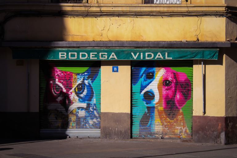 A building with a mural of dogs painted on the side of it — Foto por Stevo na Unsplash