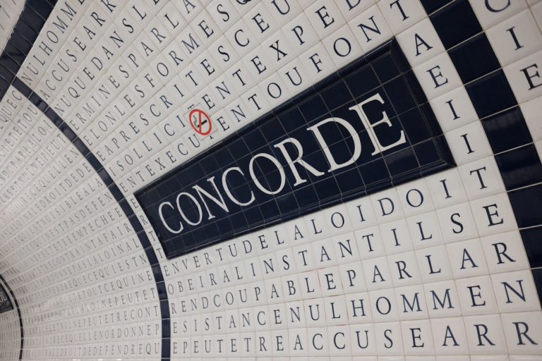a close up of a tiled wall with words — Foto por Michael na Unsplash