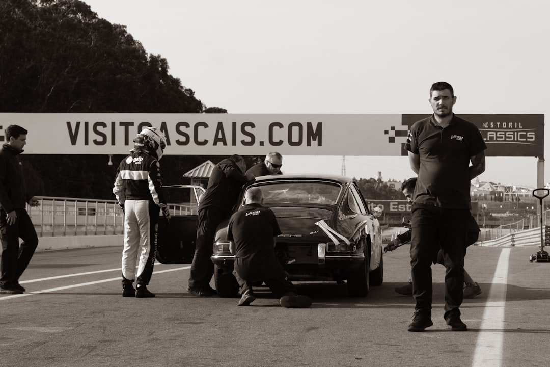 a group of people standing around a car that has crashed into a car — Foto por Rui Alves na Unsplash