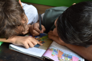 boy's writing on book — Foto por Andrew Ebrahim na Unsplash